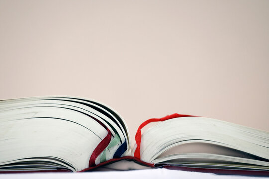A close-up of an open missal, with multicolored ribbon bookmarks marking the liturgical pages.