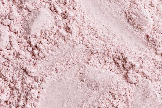 Close up texture background of fine soft pink cosmetic powder loose makeup