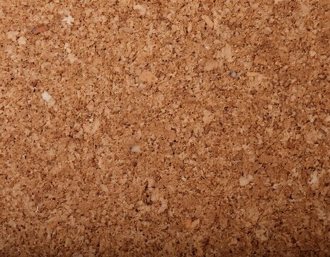 brown textured cork board backdrop with a uniform surface featuring irregular dark specks ideal for bulletin or display purposes