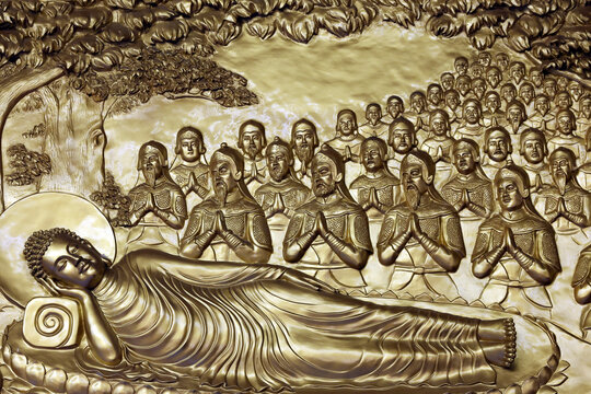 Vietnam Quoc Tu Pagoda. A relief sculpture depicting the Buddha in the parinirvana posture, surrounded by his disciples and devotees in prayer. Ho Chi Minh City, Vietnam.