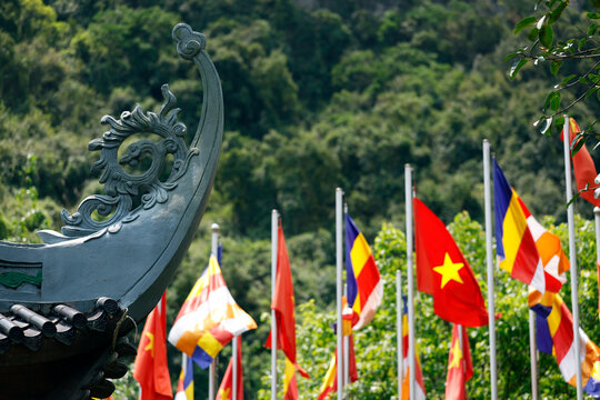 Bai Dinh Pagoda. A cluster of Vietnamese and Buddhist flags flutters in front of a Buddhist temple. Ninh Binh, Vietnam.