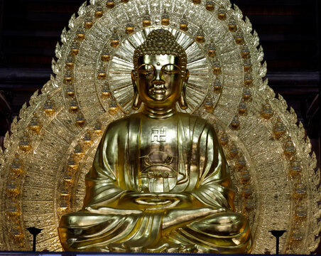 Bai Dinh Pagoda. A gilded statue of Shakyamuni Buddha in meditation, hands in dhyana mudra, guardian of the present awakening. Ninh Binh, Vietnam.