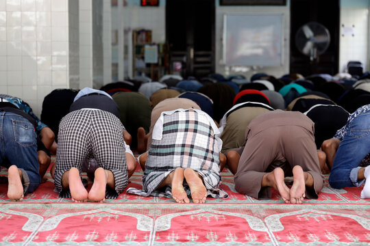 Muslim worshippers pray in a mosque, expressing their faith and devotion during a moment of collective reflection.