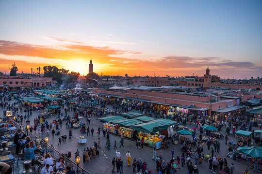 Crowds browse and dine at the bustling Jemaa el Fnaa square during a Marrakech sunset