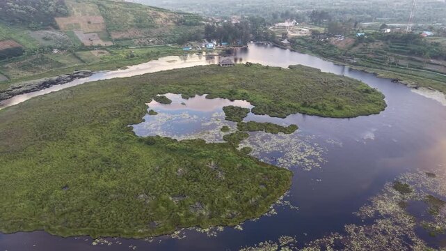 Aerial Drone View of Danau Mas Lake Surrounded by Tropical Forest in Indonesia, 4K