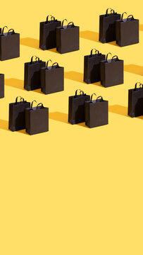 Pttetn made from black paper shopping bags on yellow background. Black friday sale, shopping concept. Banner.