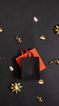 Black friday sale, shopping concept. Red and black paper shopping bags with decorations on black background.