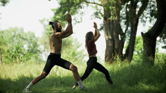 People Practicing Yoga In Forest Warrior Pose. Relaxation. Harmony And Meditating