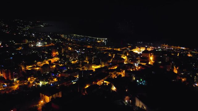 Night aerial perspective of Sanremo marina and waterfront glowing under dark sky