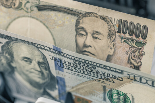 Japanese Yen versus US Dollar banknotes inside currency counter machine. Japan financial market analysis, forex exchange rate and international banking business background.