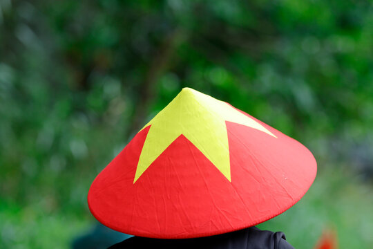 Hoa Lu, Vietnam. A traditional Vietnamese conical hat, adorned with a yellow star on a red background. This iconic accessory is an integral part of Vietnamese culture.