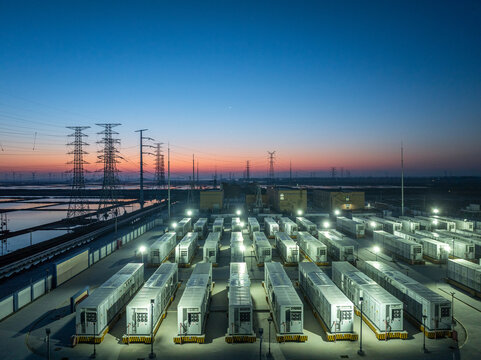 Energy storage power station with battery container arrays illuminated at dusk