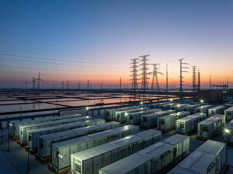Energy storage power station at dusk with equipment arrays and transmission towers