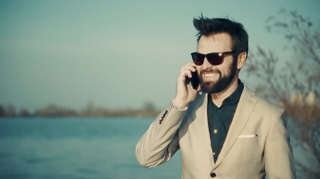 Smiling Businessman Talking On Smartphone Outdoor Standing Near Water. Business Call 