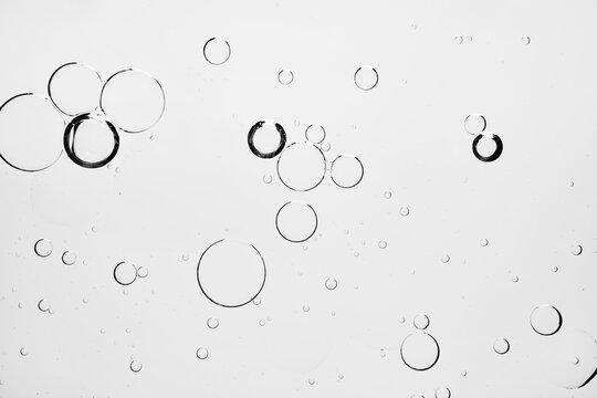 Air bubbles in transparent liquid on white background, abstract scientific or beauty texture
