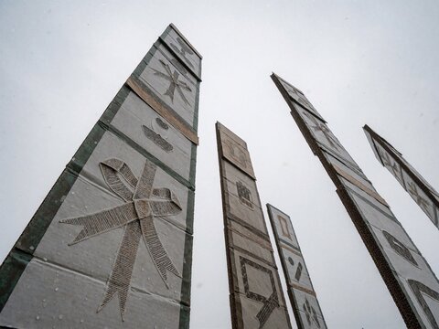 Low angle view of towering handmade cardboard placards and monuments against overcast sky