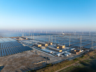 Solar photovoltaic power station and wind farm landscape under clear blue sky with morning light