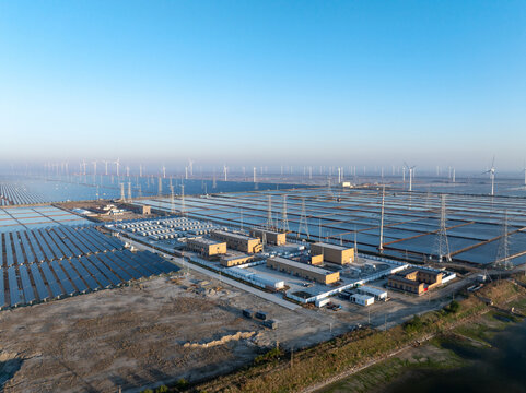 Solar photovoltaic power station and wind farm landscape under clear blue sky with morning light