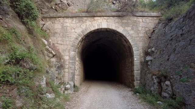 Ancient Stone Railway Tunnel Entrance in Mountain Landscape with Slow Camera Pull Back