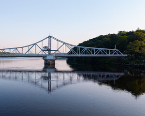 Fototapeta premium Summer aerial view featuring the East Haddam Swing Bridge along the Connecticut River in East Haddam, Connecticut just after sunrise