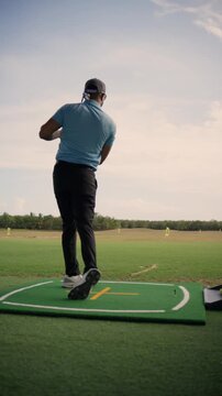 Athletic man practicing his golf swing with an iron club on a beautiful sunny day