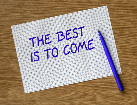 The inscription: The best is yet to come on a piece of paper and a marker on the table.