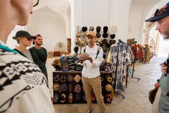 Tourists Learns About Local Hats in Uzbek Market 