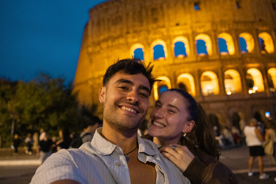 Couple smiling for a selfie by the Colosseum in Rome