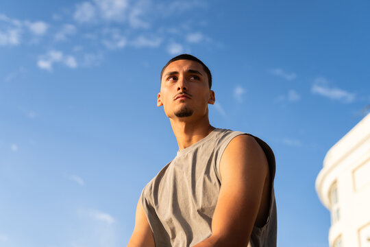 A man looking around under a blue sky at sunset. Copy space