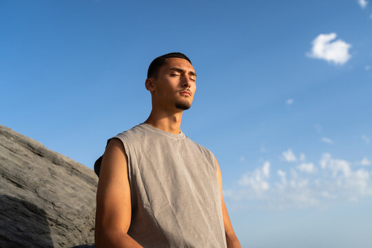 A relaxed man with his eyes closed against a blue sky. Copy space