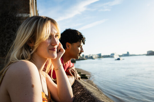 Young couple sharing a peaceful moment by the river promenade
