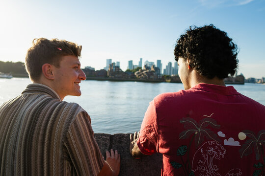 Friends talking by the River Thames with London skyline background