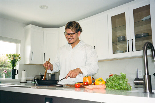 Mobile phone hispanic Young man in Kitchen prepare meal film 