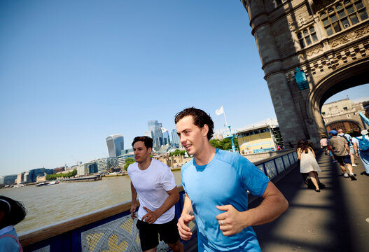 Two men jogging over Tower Bridge in London.