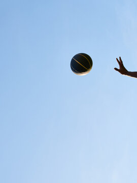 Basketball Player Throws Ball Into Blue Sky During Daytime
