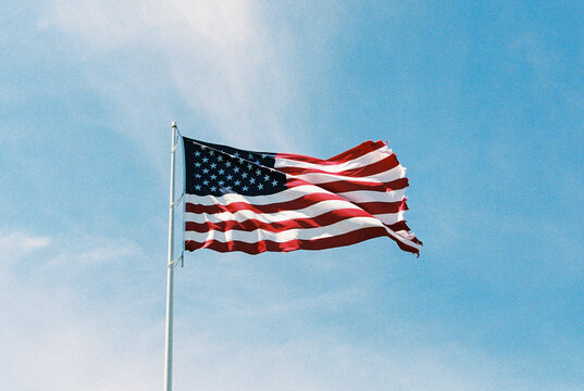 American flag flies again a blue summer sky