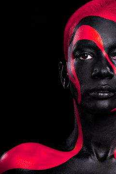 The Art Face. Close-up portrait. Black and yellow body paint on african woman. Abstract creative portrait. Bright fashion makeup on the girl.