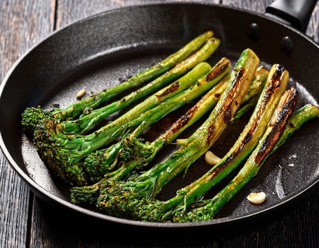 charred broccolini spears in a black pan