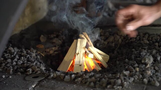 A Glimpse into the Art of Firecraft: Igniting Flames with Careful Placement of Kindling and Managing Heat with Primitive Techniques