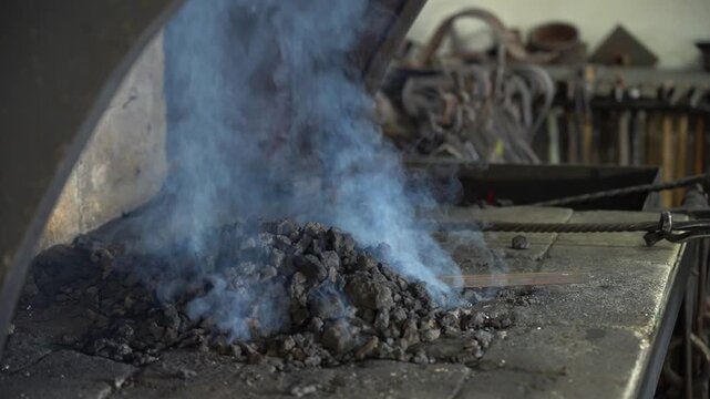 A Close-Up Look at the Process of Blacksmithing with Glowing Forge and Billowing Smoke Rising from the Anvil, Showcasing the Artistry and Techniques of Metalworking