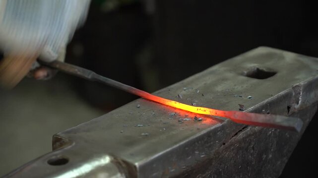 Craftsmanship in Action: A Skilled Metalworker Shaping Hot Metal with Precision and Strength on an Anvil, Creating Intricate Designs in the Art of Blacksmithing