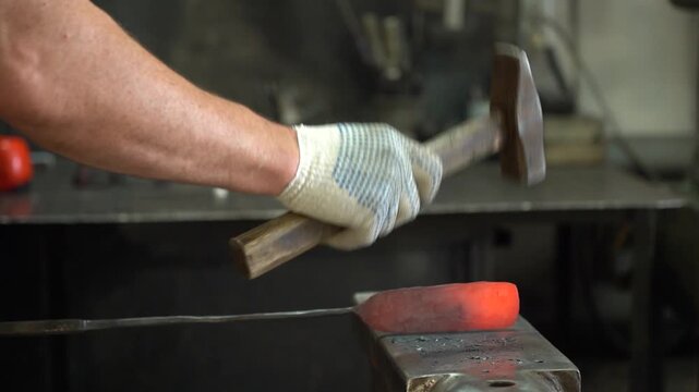 Crafting Metal: A Skilled Blacksmith Shapes Steel with Precision and Strength while Hammering a Red Hot Metal Bar on an Anvil in a Forging Workshop