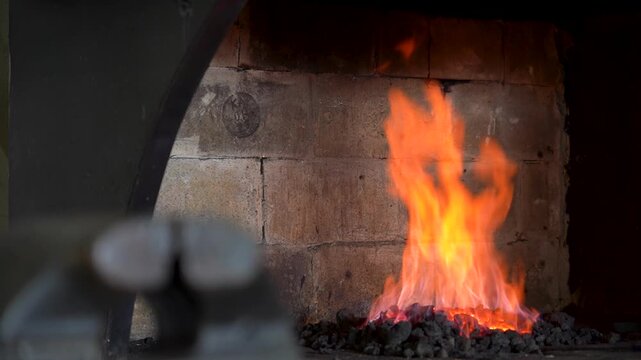 The Intense Dance of Flames: Capturing the Transformation of Coals in a Blacksmith's Forge from Fiery Embers to Blazing Inferno