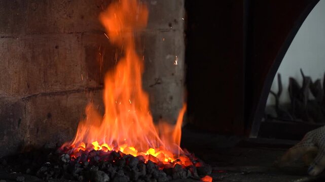 A Blacksmith's Craft: The Art of Forging Metal in a Fiery Hearth, Showcasing the Vibrant Flames and Glowing Coals Burning Bright in the Forge