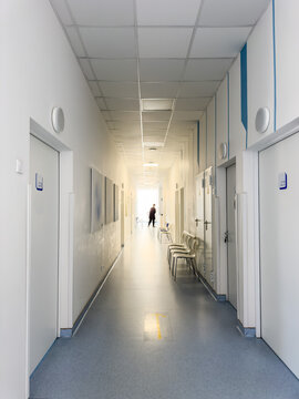Bright hospital corridor hallway in modern clinic with medical doors, chairs and treatment rooms. Clean healthcare interior