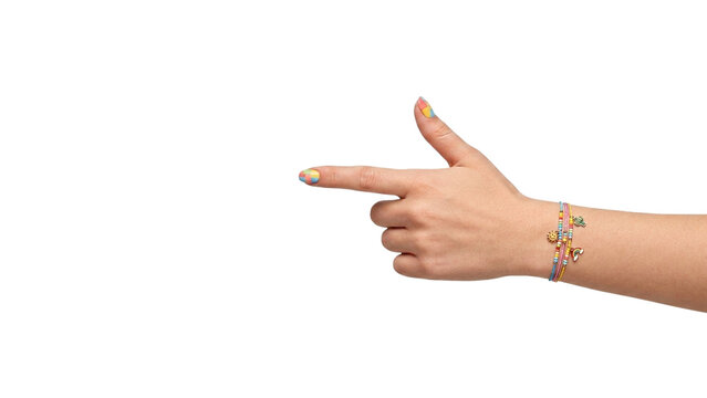 Stylish female hand making a finger-gun pointing gesture to the left, decorated with colorful nail polish and layered charm bracelets, isolated on transparency PNG asset