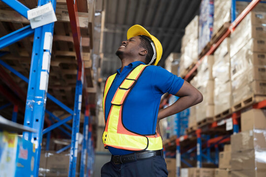 Warehouse, deposit or store. African American warehouse worker have accident during working in warehouse. Worker have sick while working