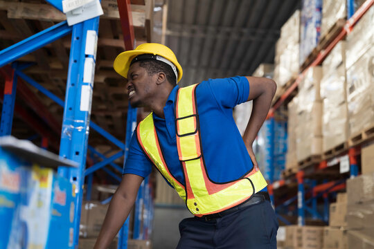Warehouse, deposit or store. African American warehouse worker have accident during working in warehouse. Worker have sick while working