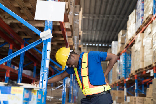 Warehouse, deposit or store. African American warehouse worker have accident during working in warehouse. Worker have sick while working
