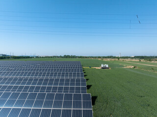 Rows of solar panels in a green field under blue sky © zhu difeng